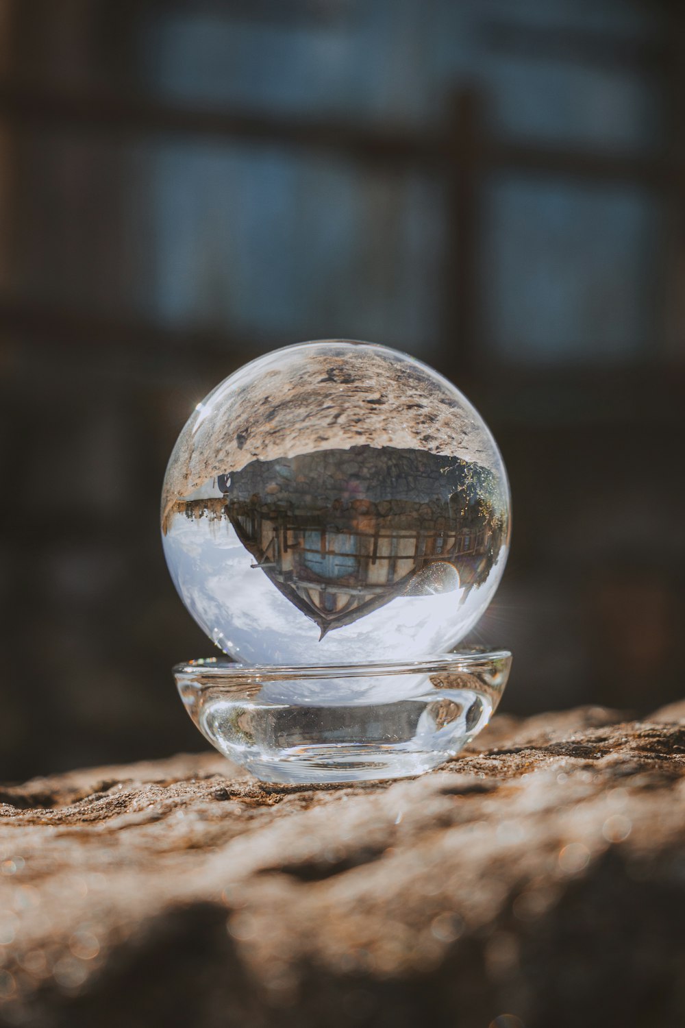 uma bola de vidro sentada em cima de uma rocha