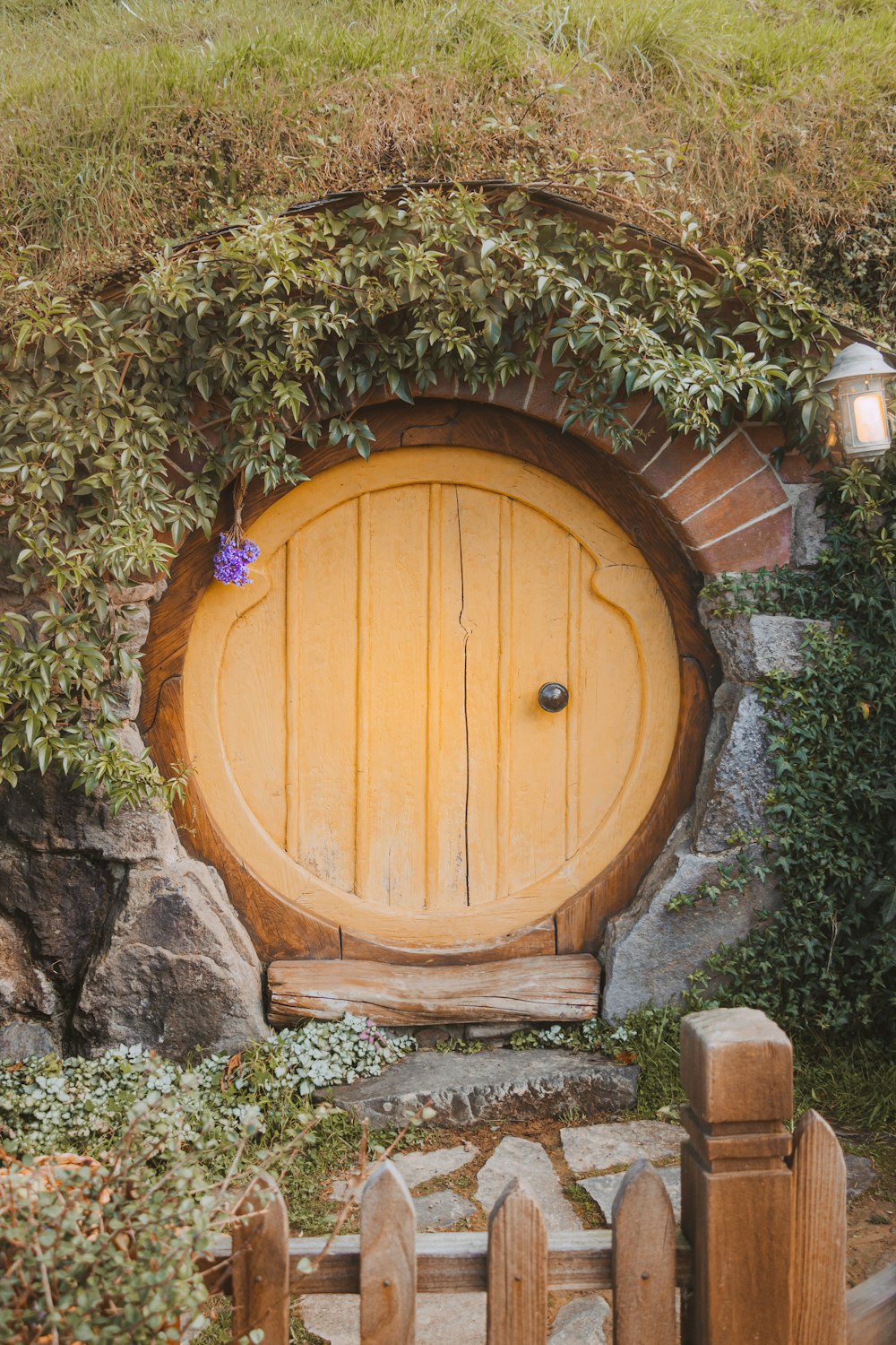 a hobbot door in the middle of a stone wall