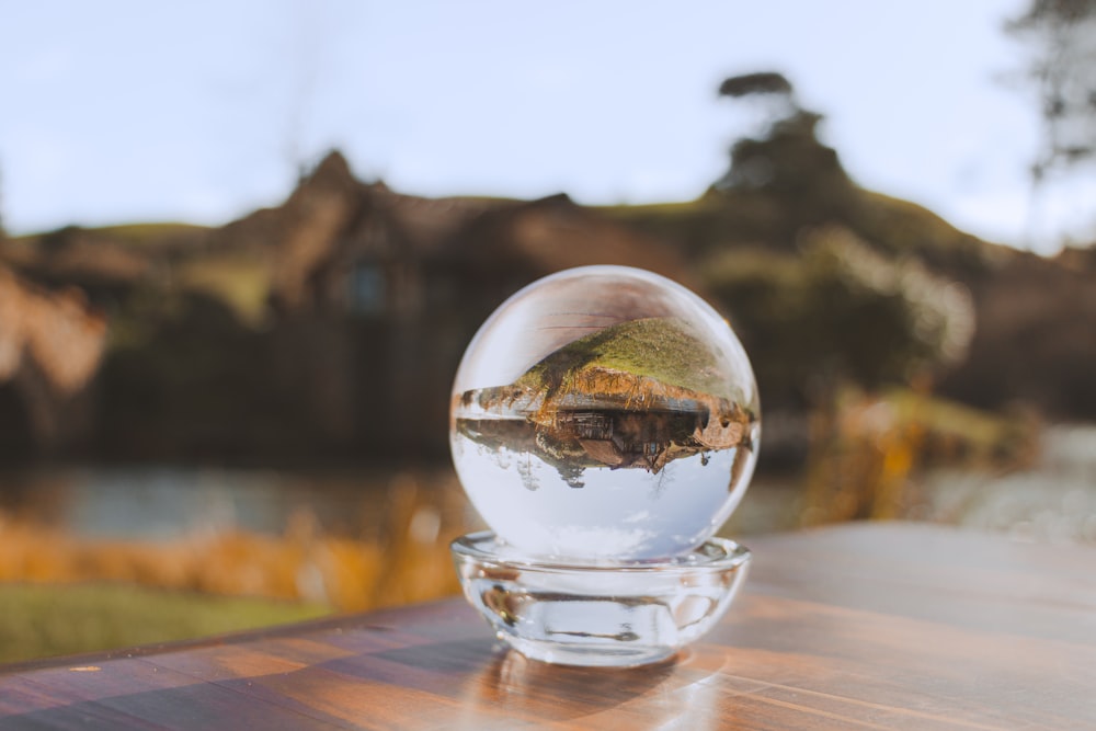 a glass ball with water inside of it on a table