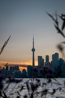 The iconic CN Tower towering over Toronto’s skyline during a glowing sunset.