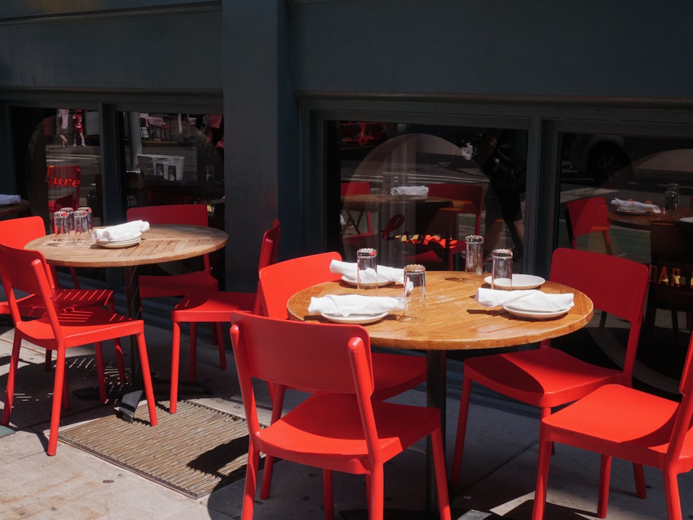 a group of red chairs sitting around a wooden table