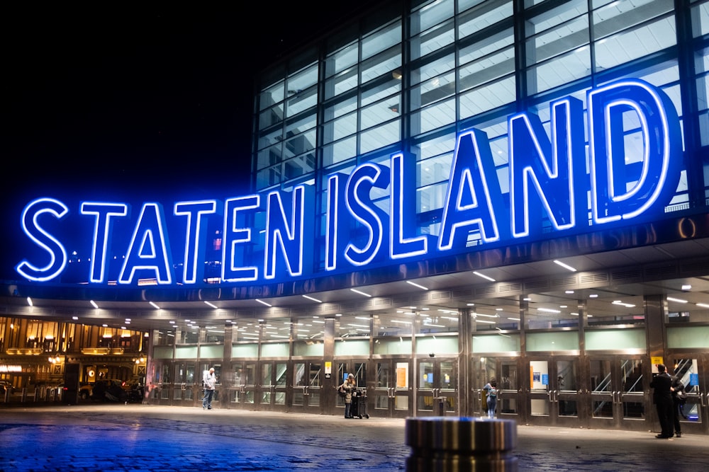 a building with a neon sign that reads state island