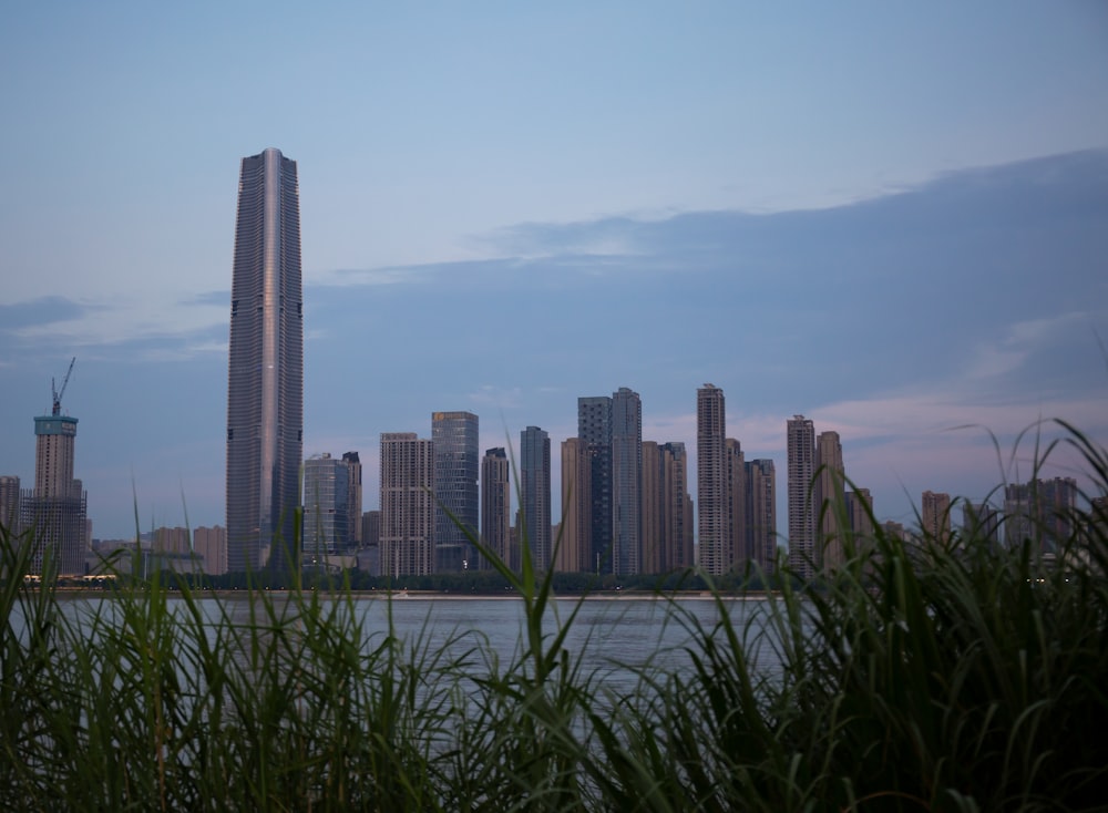a city skyline with tall buildings and a body of water