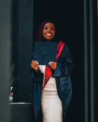 Close-up of a graduate holding a diploma with a big smile.