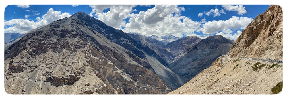 a scenic view of a mountain range with clouds in the sky