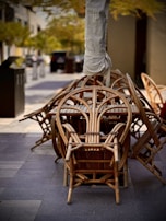 Stacked outdoor chairs with neatly embroidered oshoo heated cushions ready for a restaurant terrace.