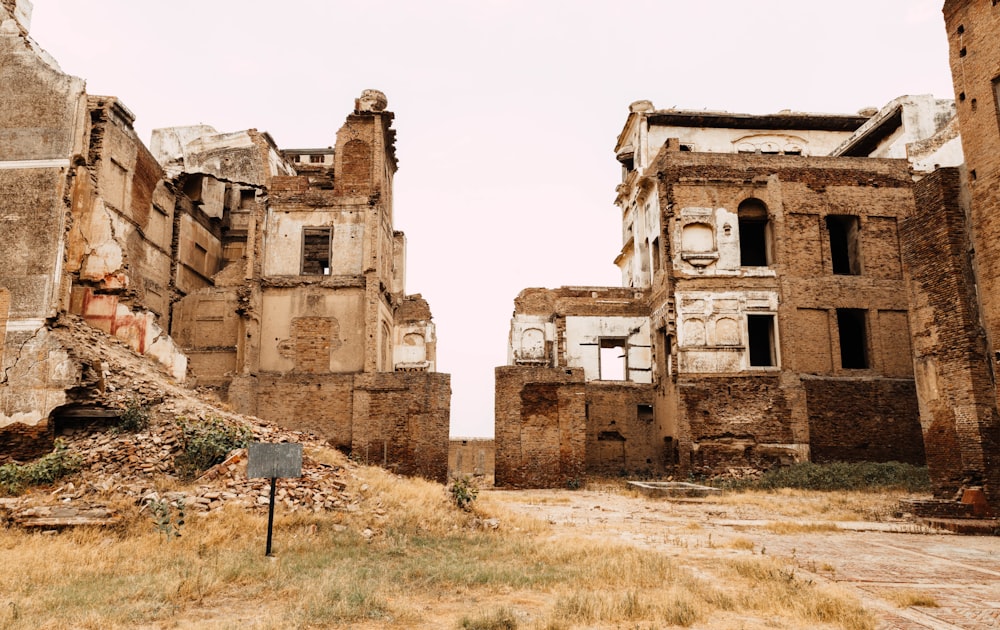 an abandoned building with a sign in the foreground