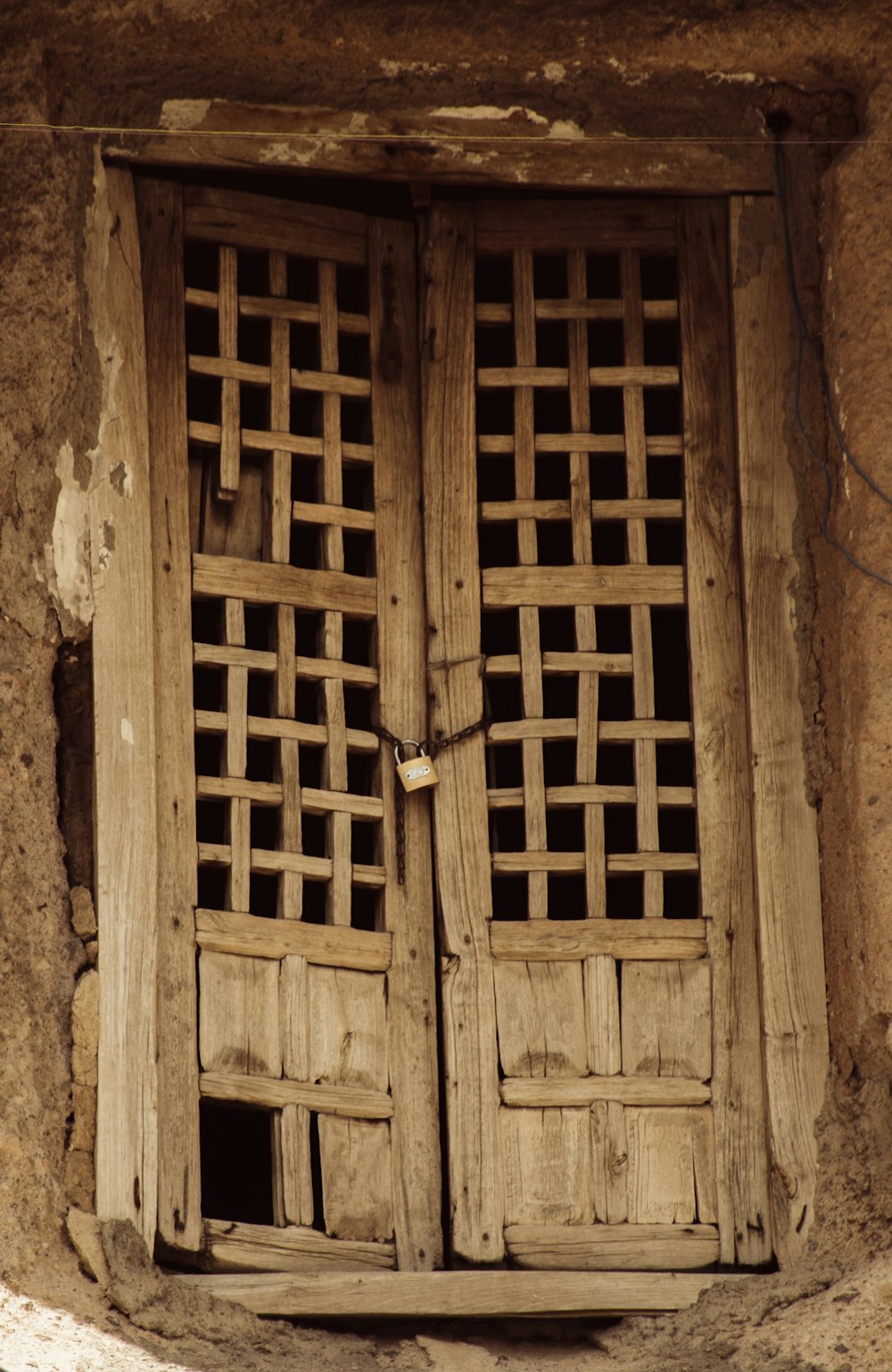 a pair of wooden doors sitting inside of a stone building