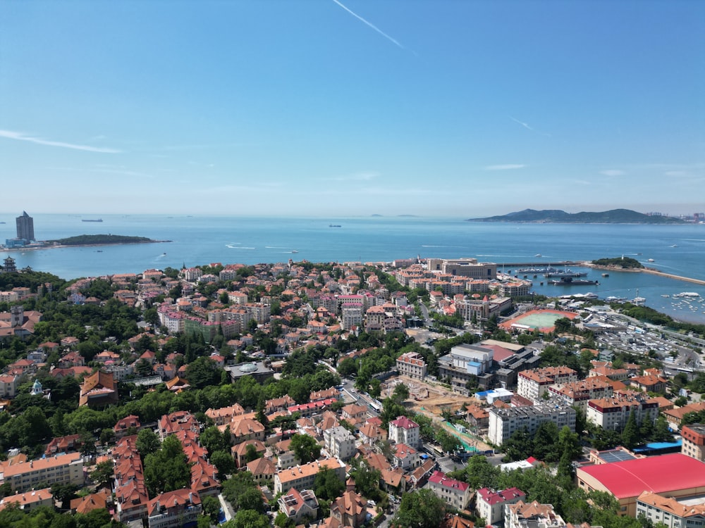 an aerial view of a city next to a body of water