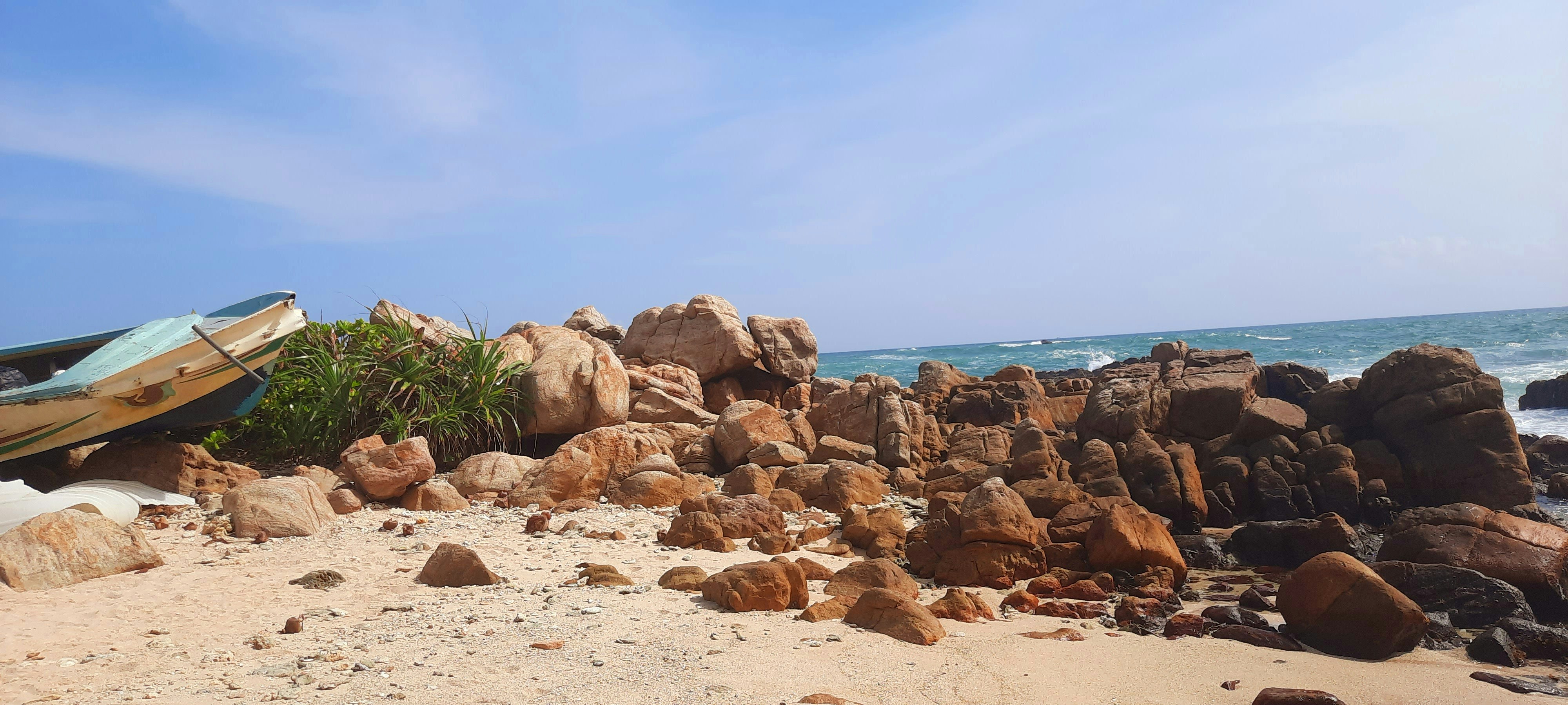 A boat sitting on top of a pile of rocks photo – Free Srilanka Image on ...