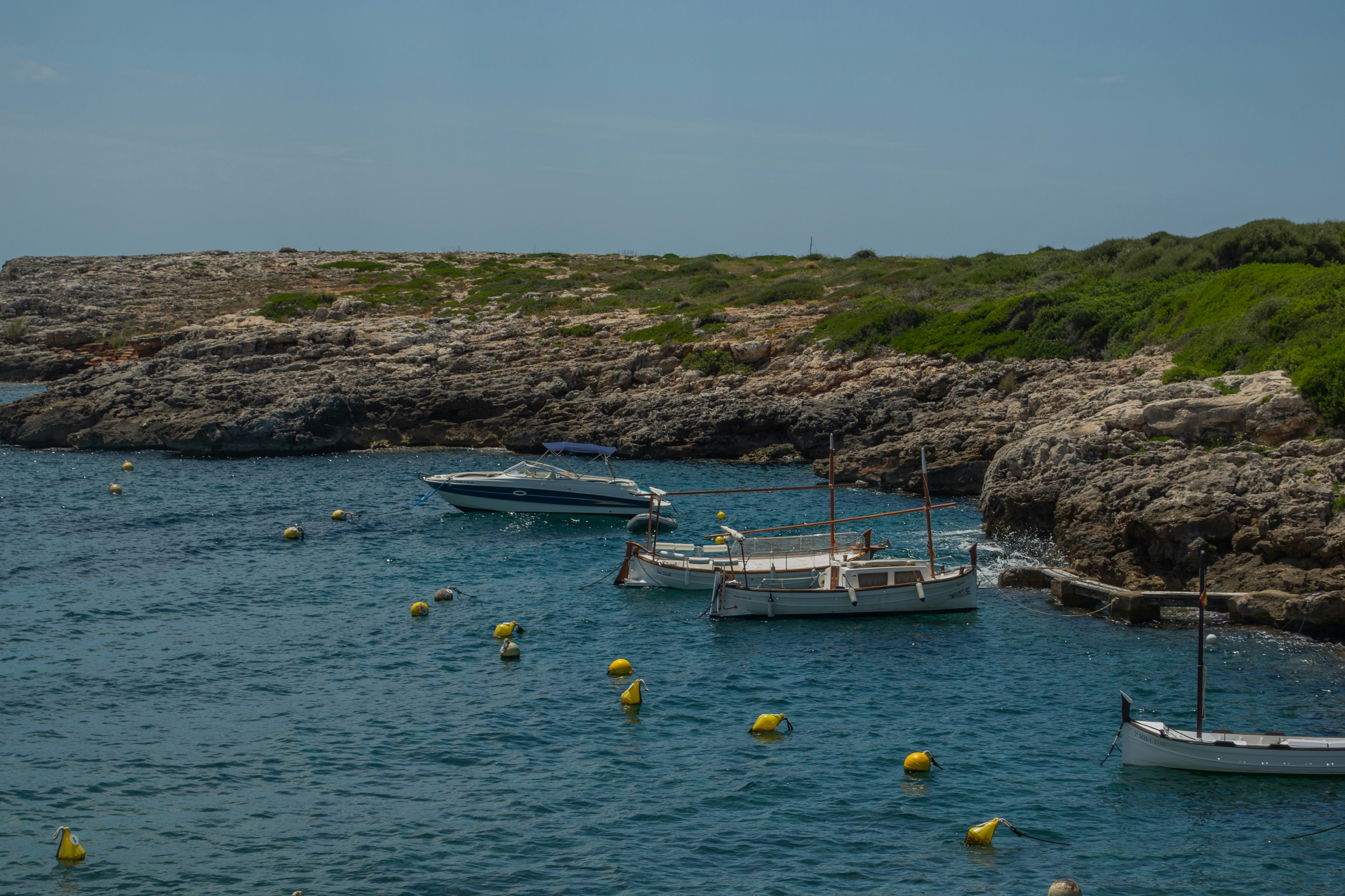 A group of boats floating on top of a body of water photo – Free Boat