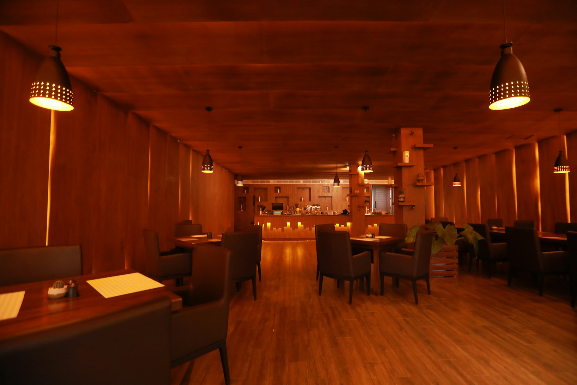 A cozy interior of a restaurant featuring warm lighting and wooden decor, creating a welcoming atmosphere.