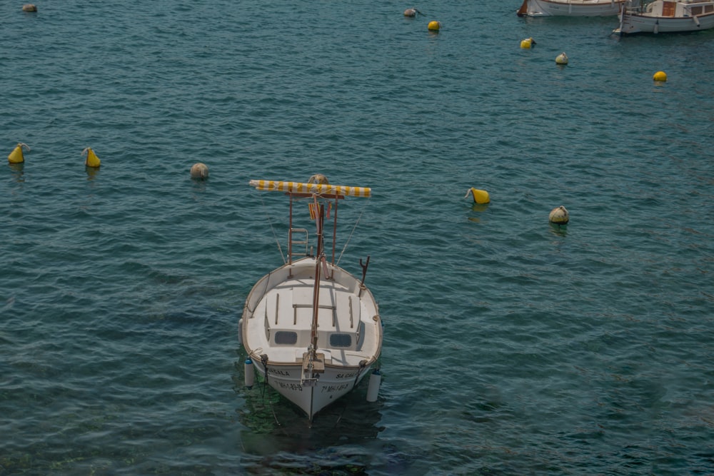 a white boat floating on top of a body of water