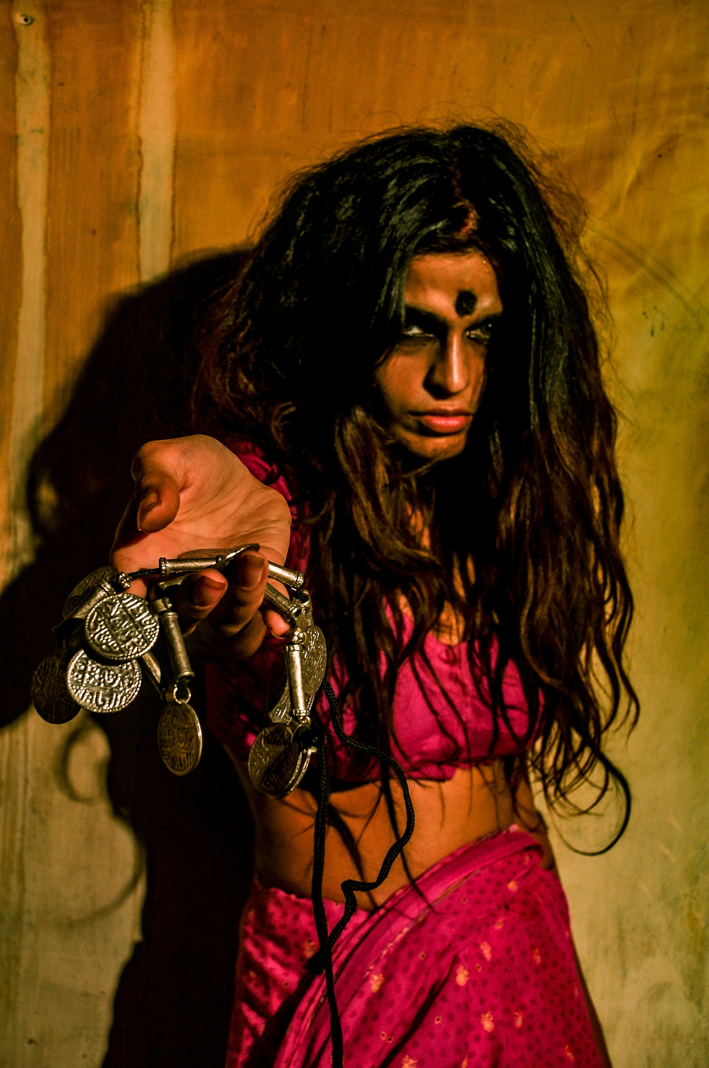 a woman in a pink sari holding a bunch of keys