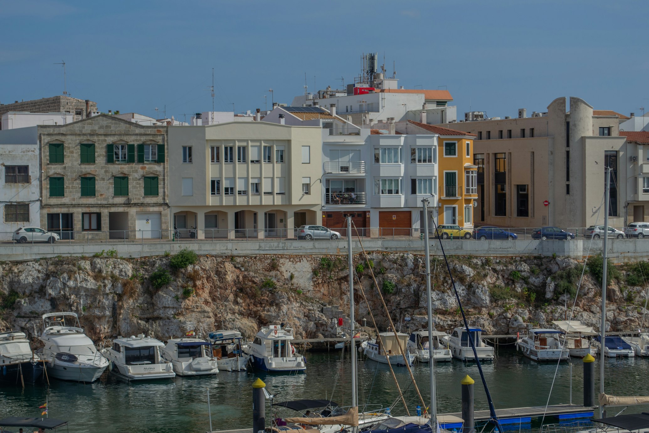 Puerto de Ciutadella, Menorca, con barcos amarrados y la ciudad de fondo. 