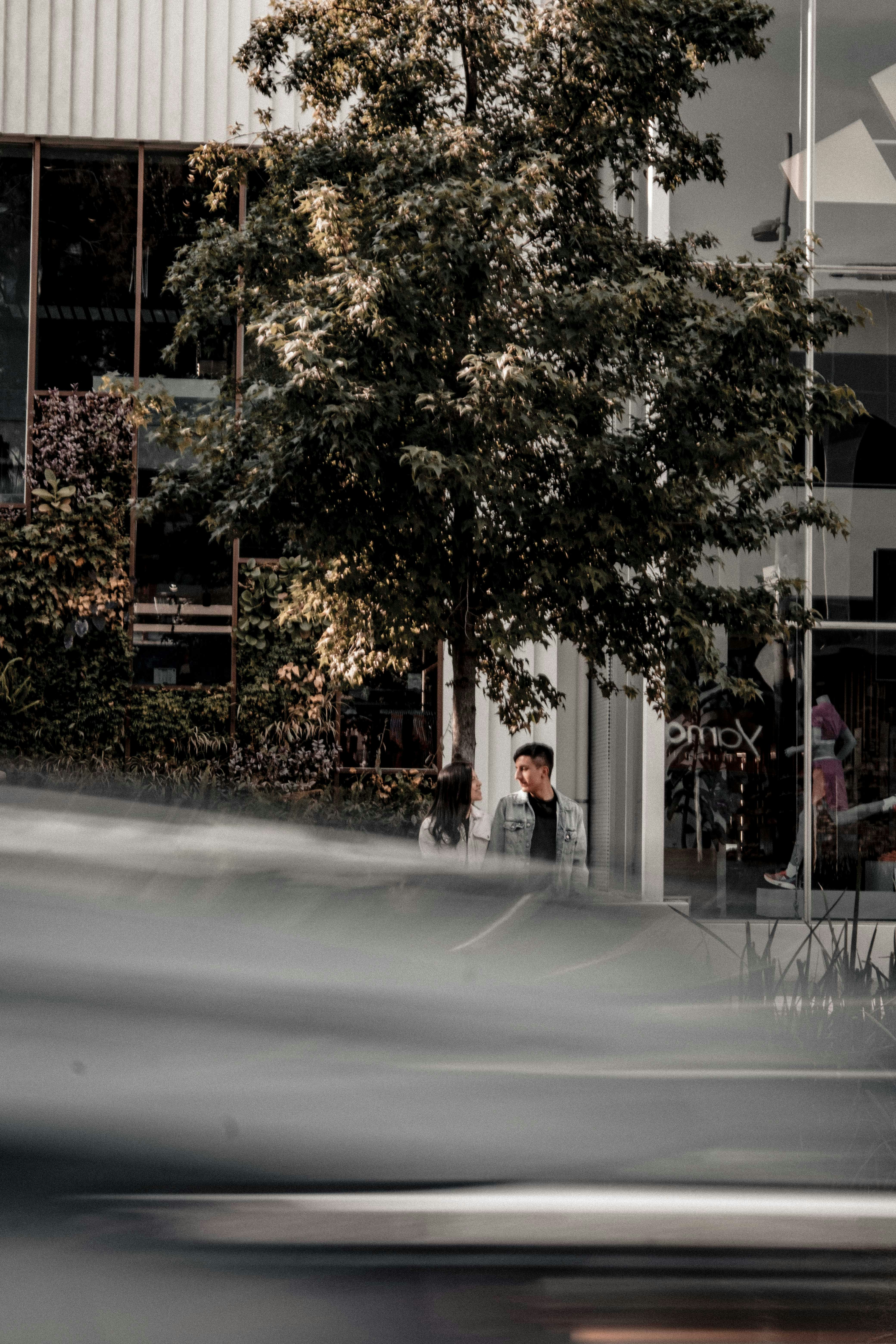a blurry photo of a man sitting at a table in front of a building