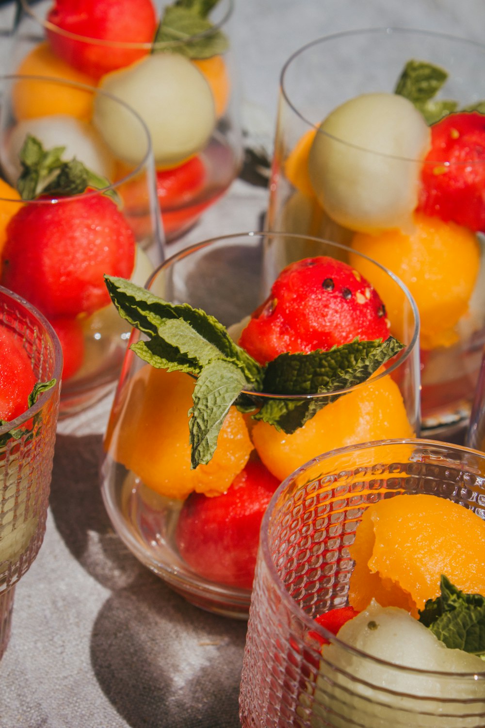 a table topped with glasses filled with fruit