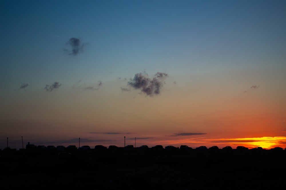 the sun is setting in the sky over a field