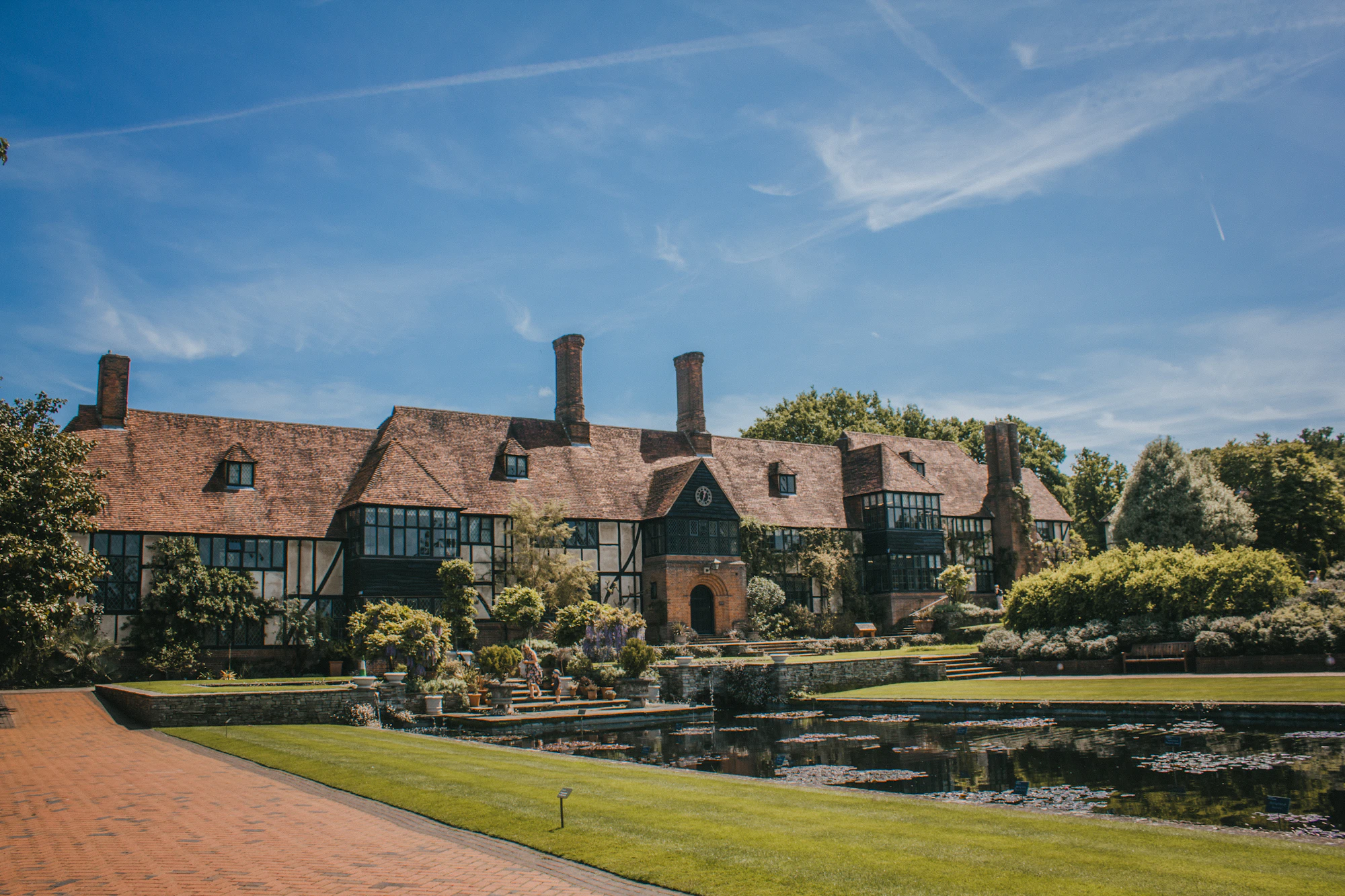 A large country house with a landscaped garden and pond