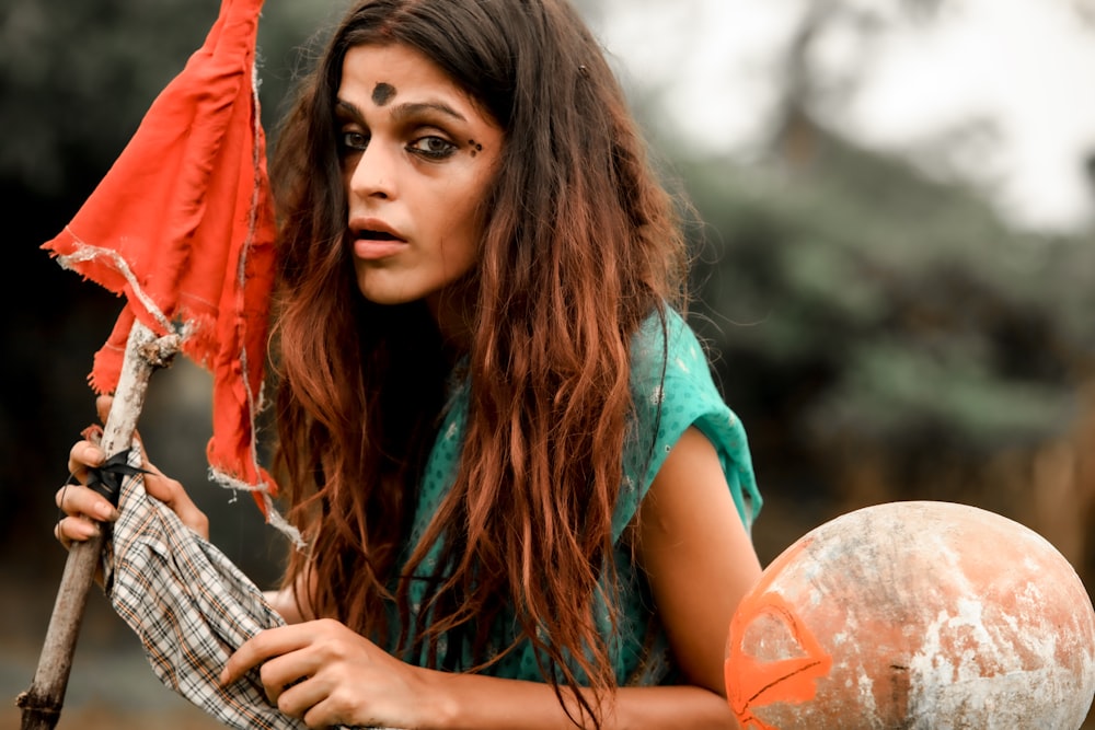 a woman with makeup holding a red umbrella