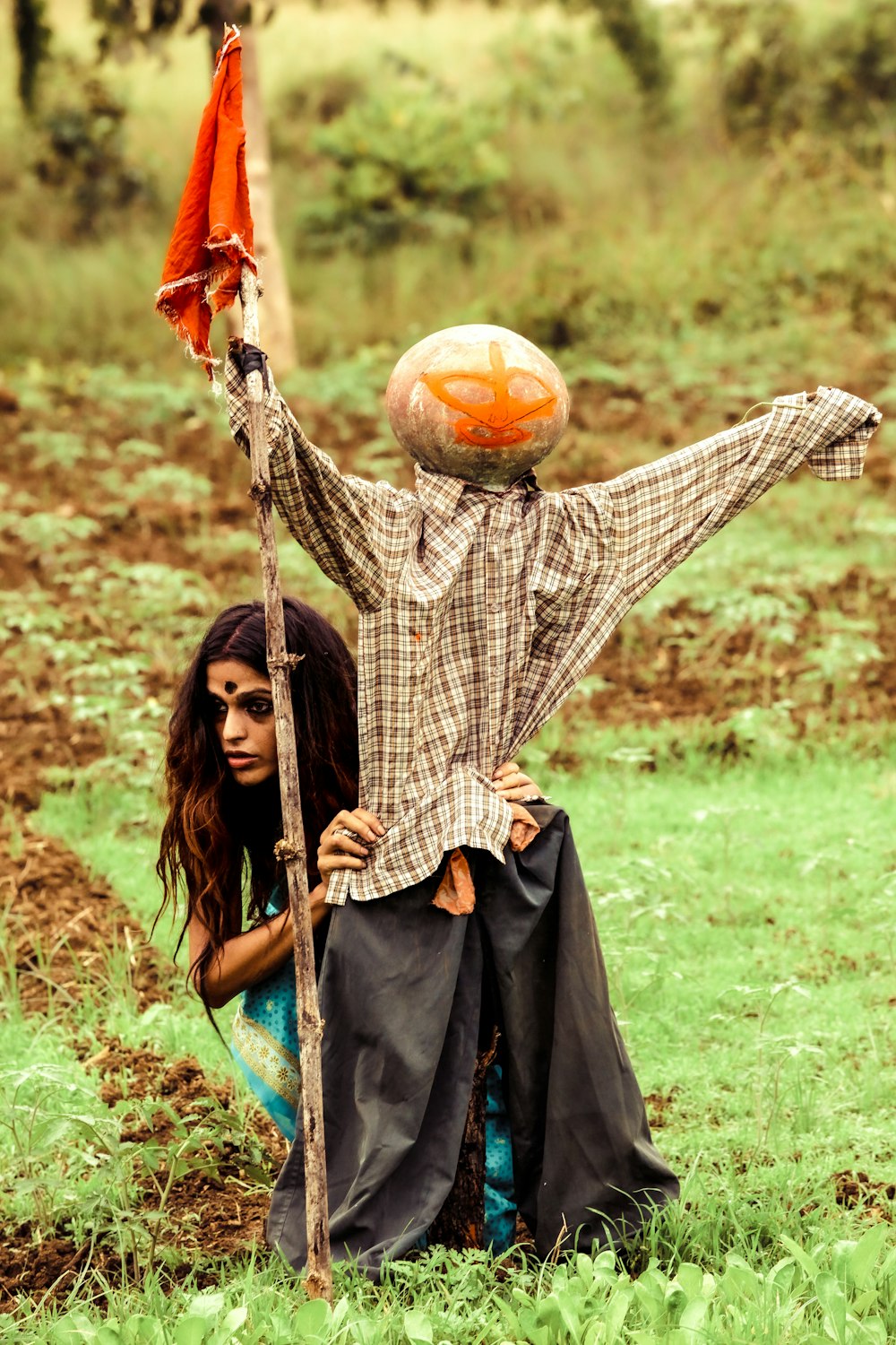 a woman holding a child on her back in a field