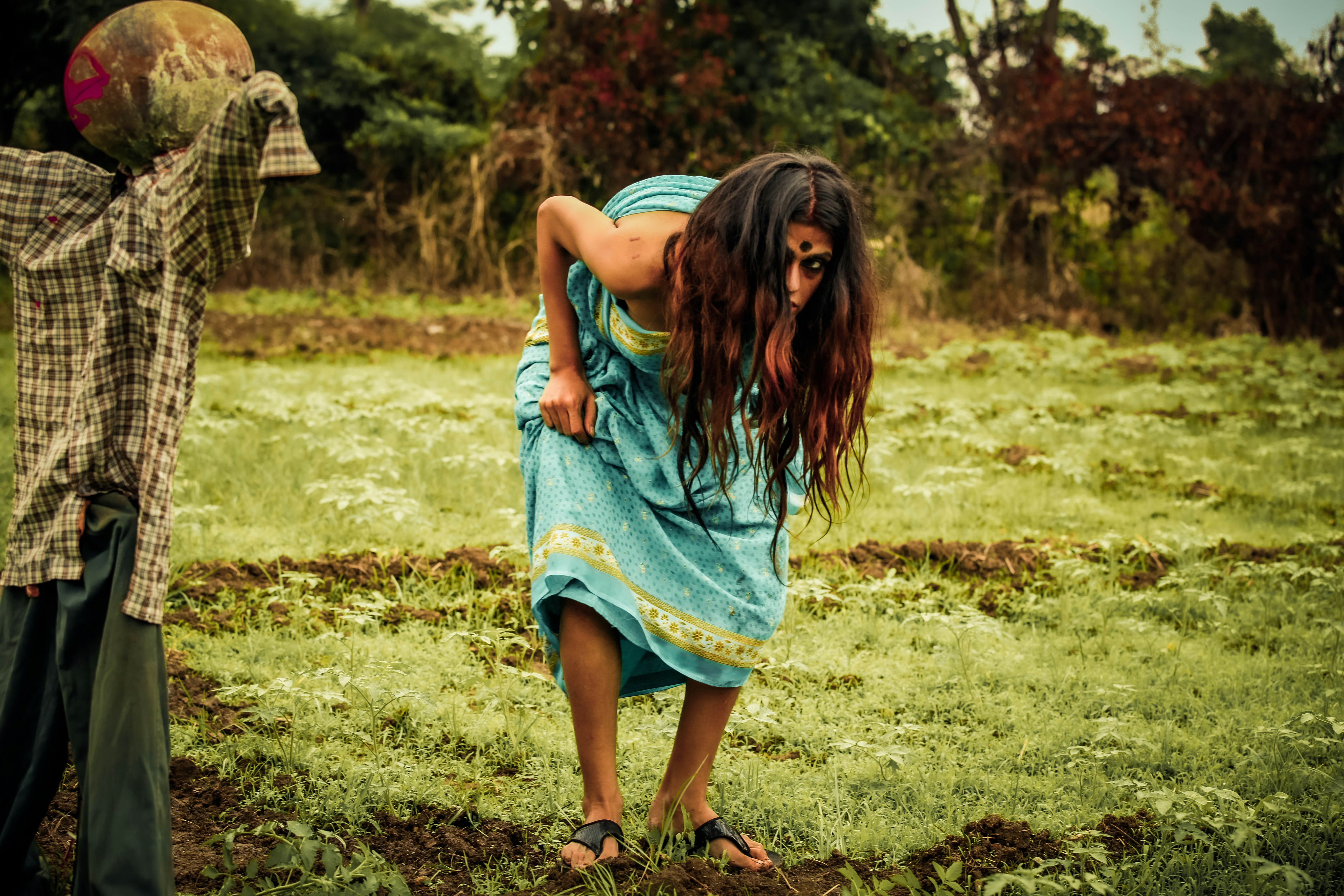 a woman in a blue dress and a man in a plaid shirt in a field