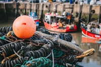 a pile of fishing nets sitting next to a body of water