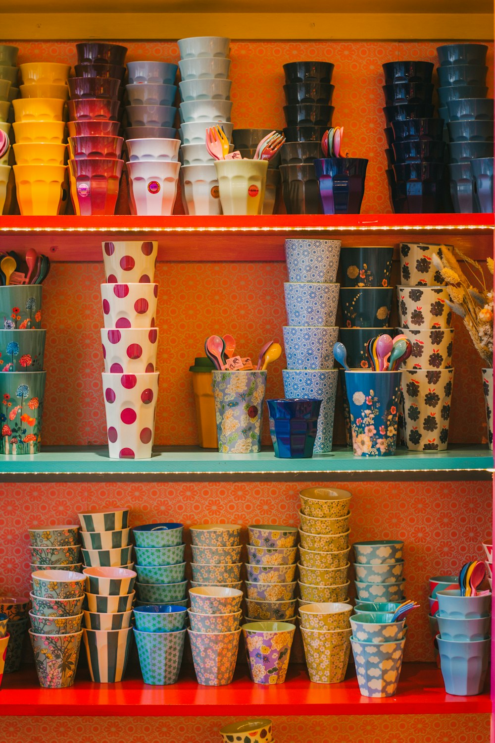Un estante lleno de muchas tazas de colores