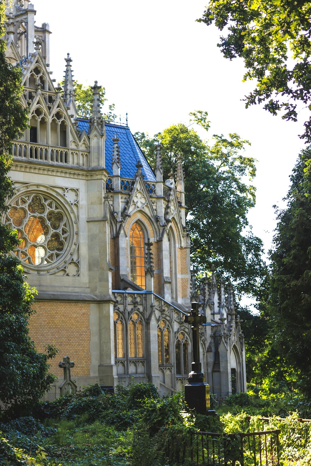 a large building with a blue roof surrounded by trees