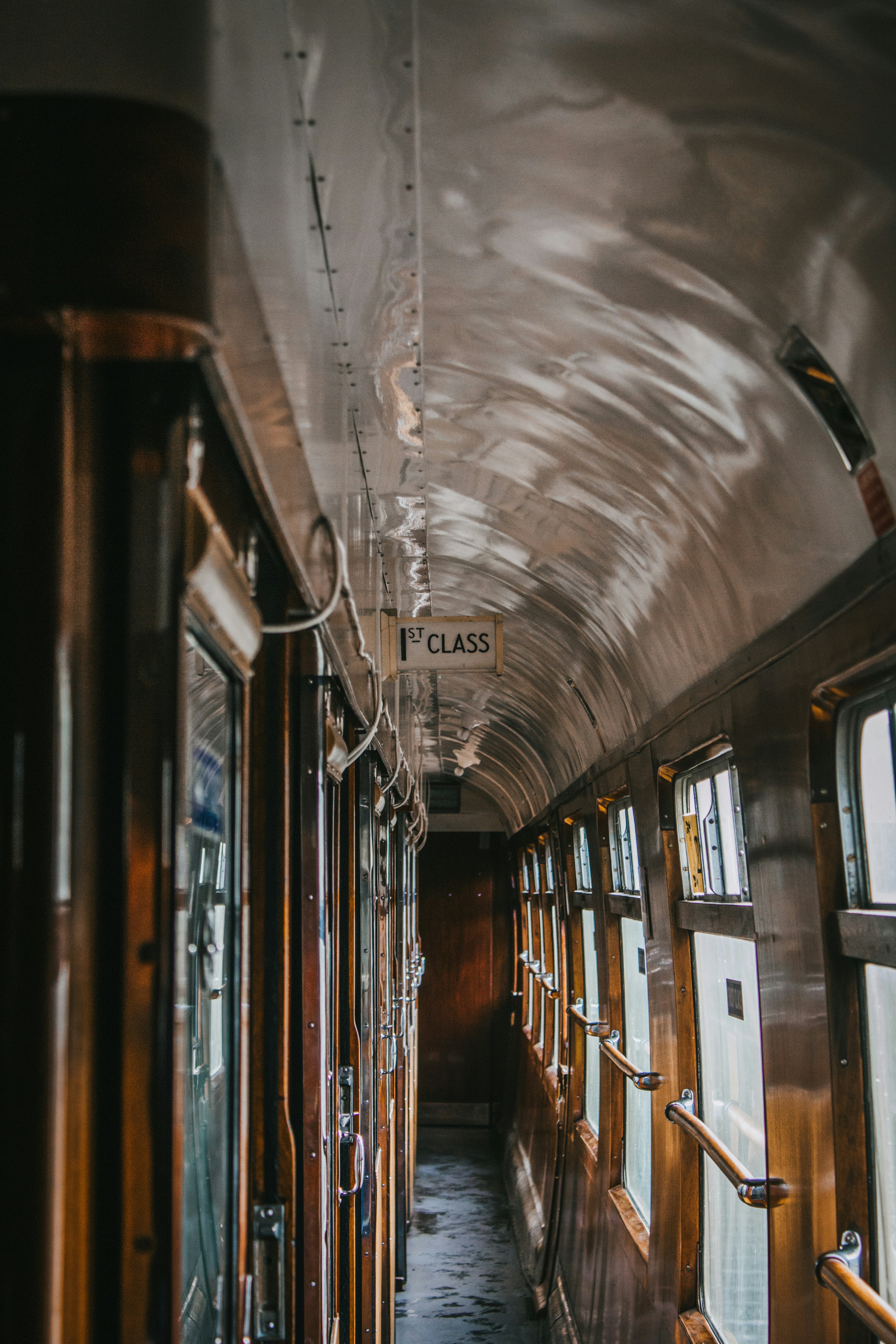 the inside of a train car with a sign hanging from the ceiling