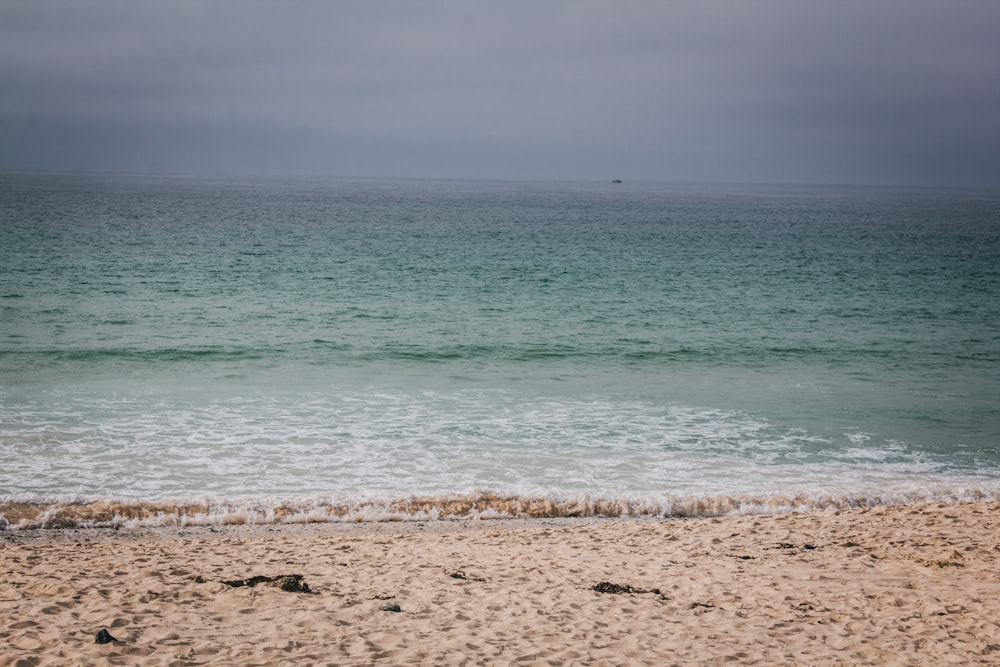 Una tabla de surf solitaria sentada en la playa junto al océano