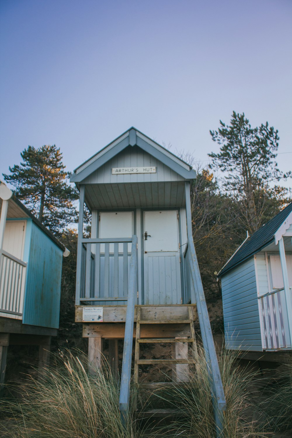 a blue and white beach hut sitting on top of a sandy beach