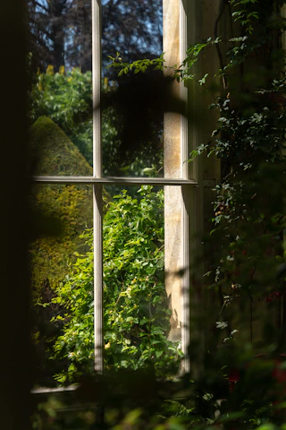 A vibrant window painting of a blooming garden scene with sunlight streaming through.