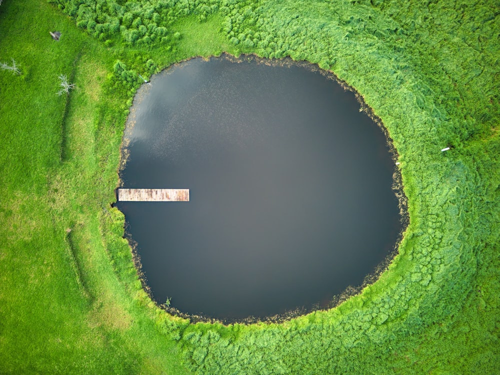 a large body of water surrounded by green grass