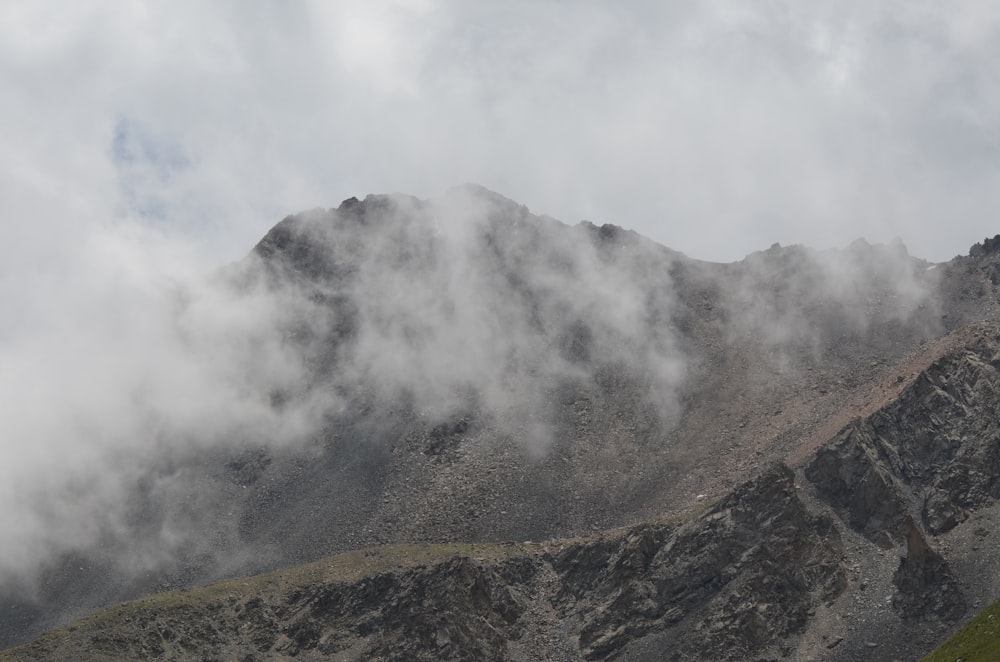 a mountain covered in clouds on a cloudy day