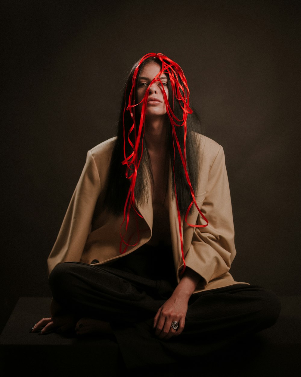 a woman with long hair sitting on a black surface