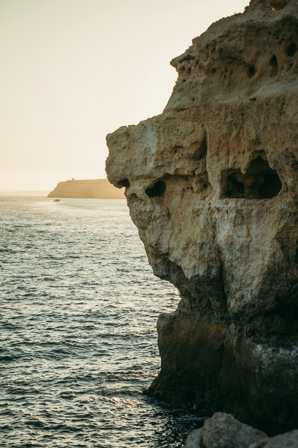 a rock formation with holes in the side of it