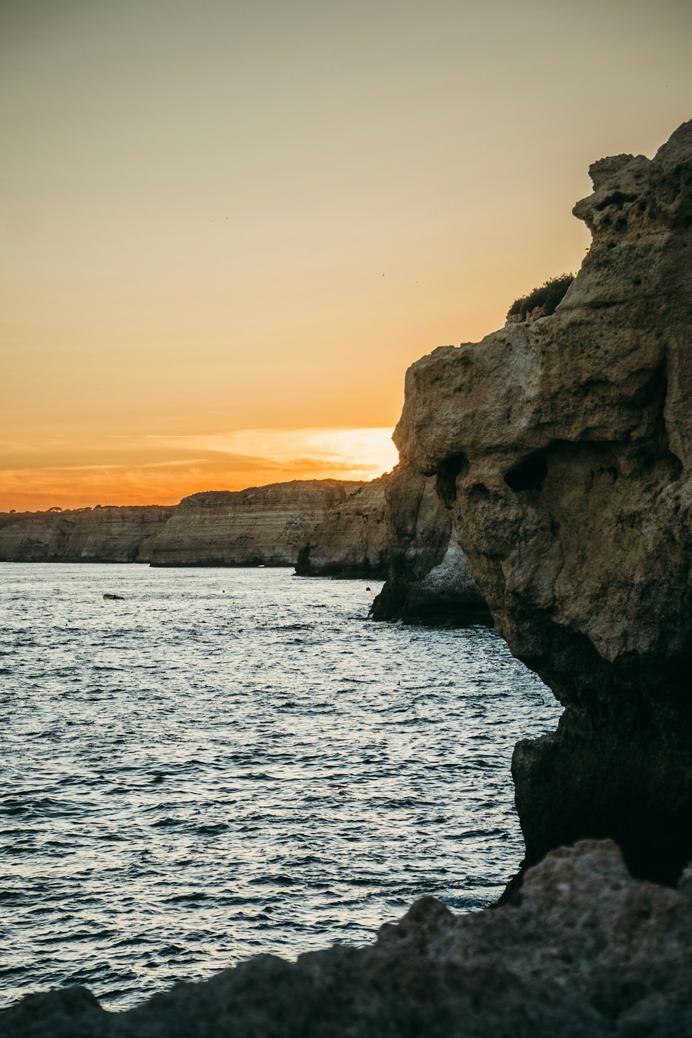 a large body of water near a rocky cliff