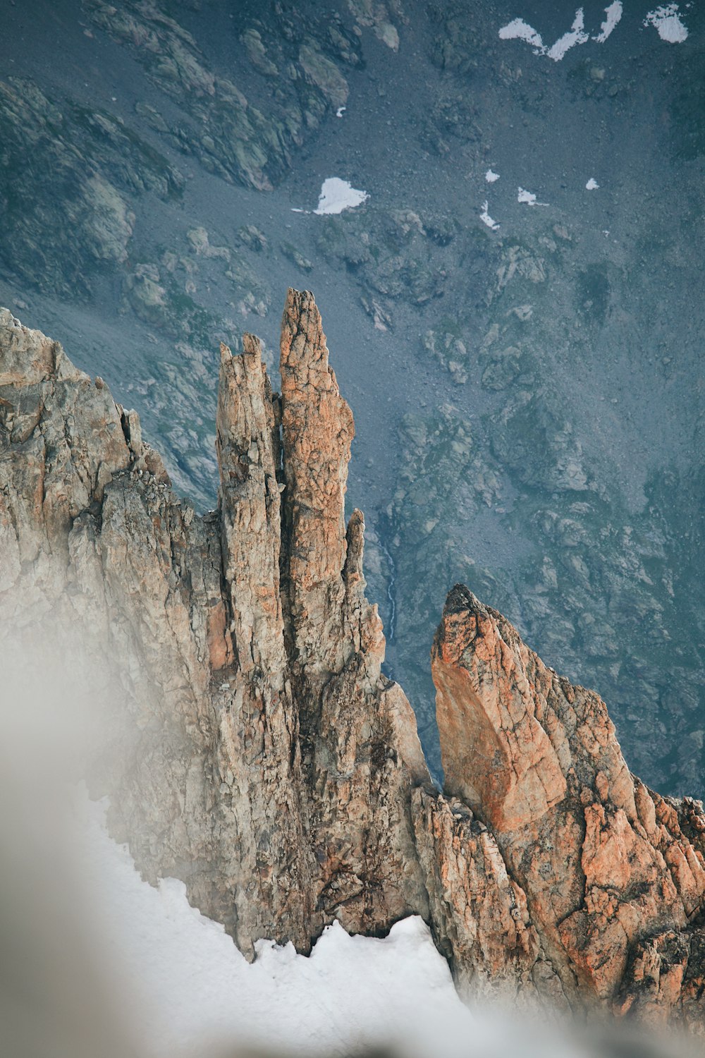 an aerial view of a mountain with snow on the ground