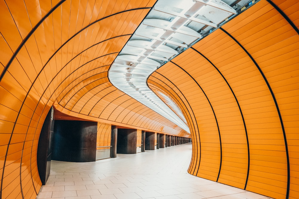 a long hallway with orange walls and a tiled floor