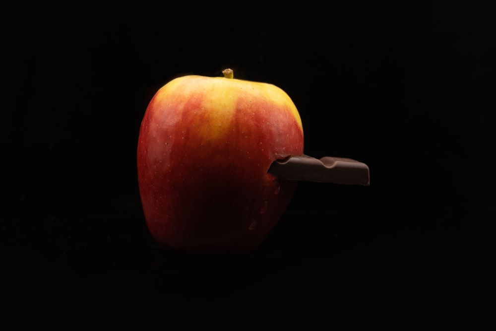 an apple with a knife sticking out of it