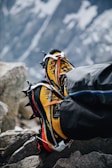 Close-up of crampons and ice axe resting on icy terrain.