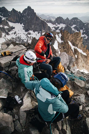 Group of climbers resting on a ledge, sharing smiles and gear.