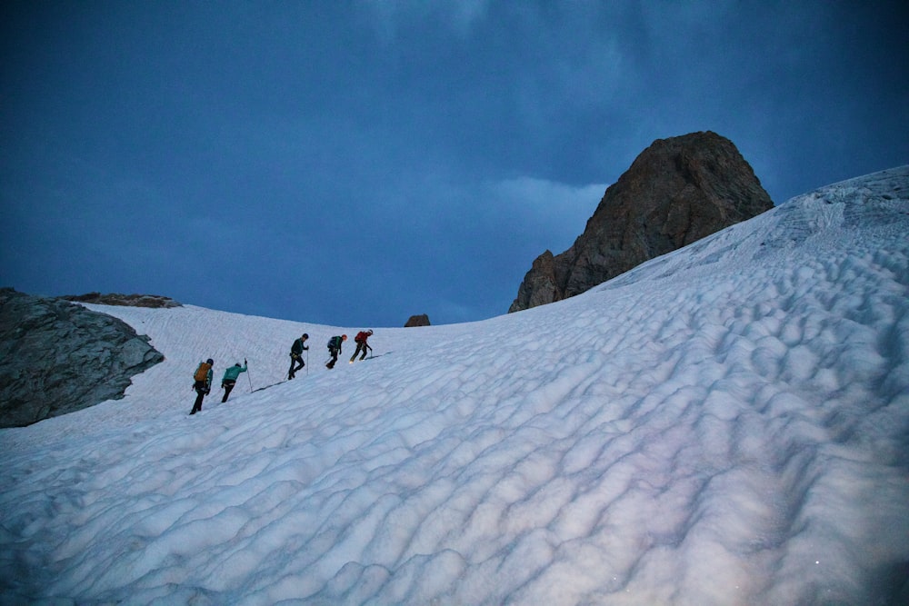 a group of people hiking up a snow covered mountain