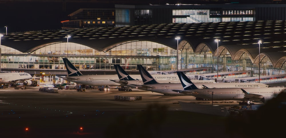 a row of airplanes parked at an airport