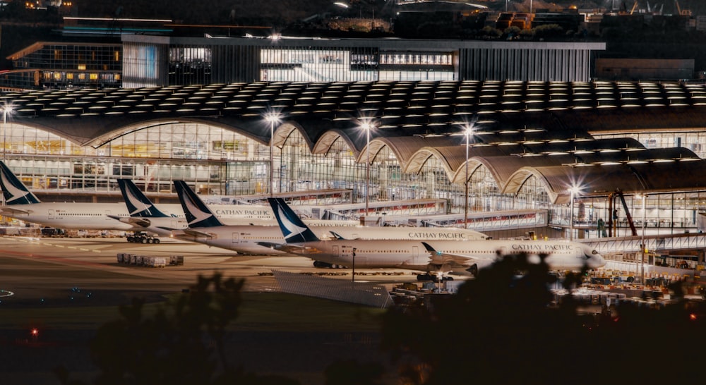 Un grupo de aviones estacionados en una terminal del aeropuerto