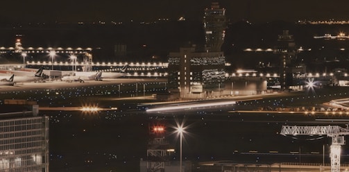 a night time view of an airport with planes parked