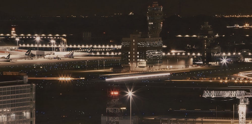 Una vista nocturna de un aeropuerto con aviones estacionados