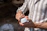 Close-up of a hand holding a glowing jar of Bright Moon Cosmetic cream against a natural background.