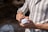 Close-up of hands holding a natural beauty product with soft sunlight in the background.